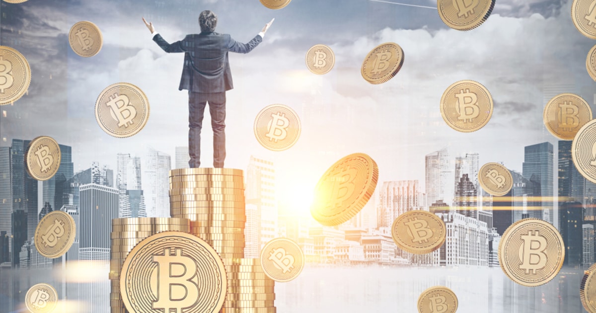 Businessman atop a pile of Bitcoins